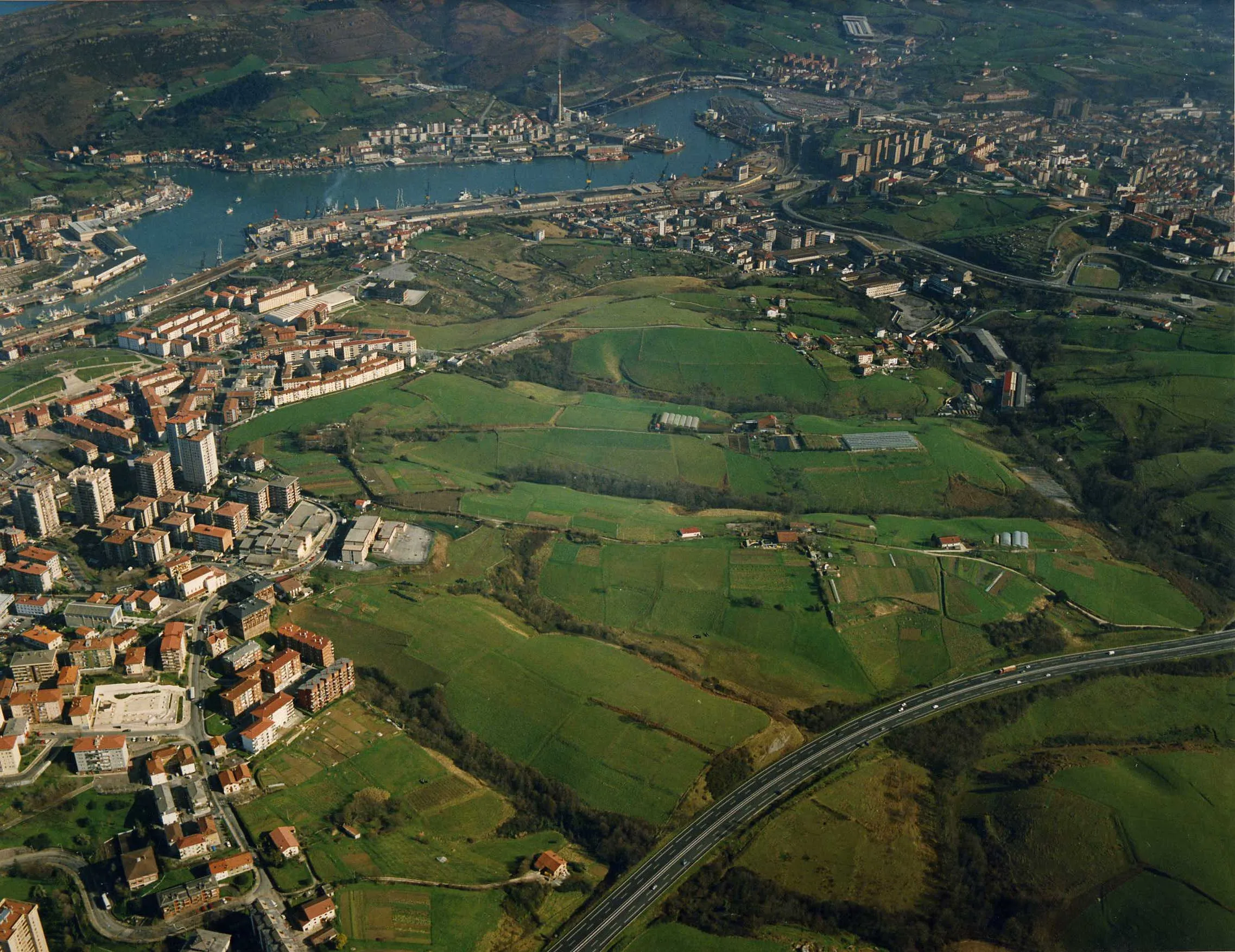 Auditz-Akular y la bahía de Pasaia desde el aire: prados entre los bloques de Altza y la autopista.